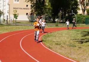 dzieci biegną po bieżni